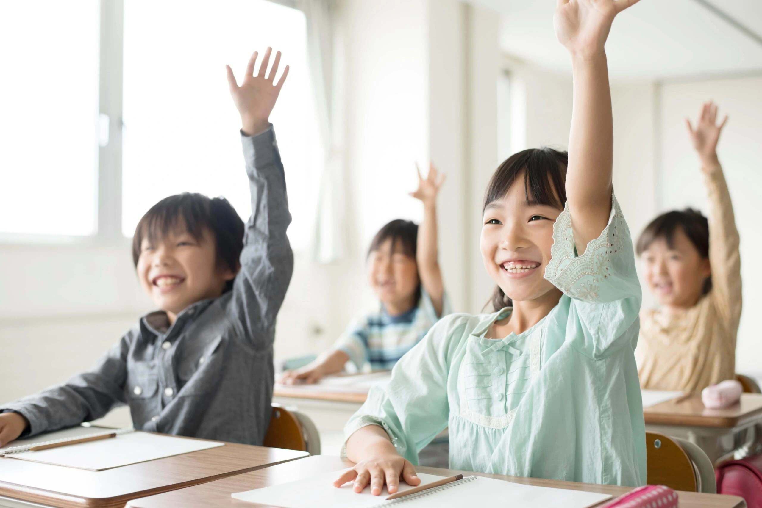 教室で手を挙げる子どもたち