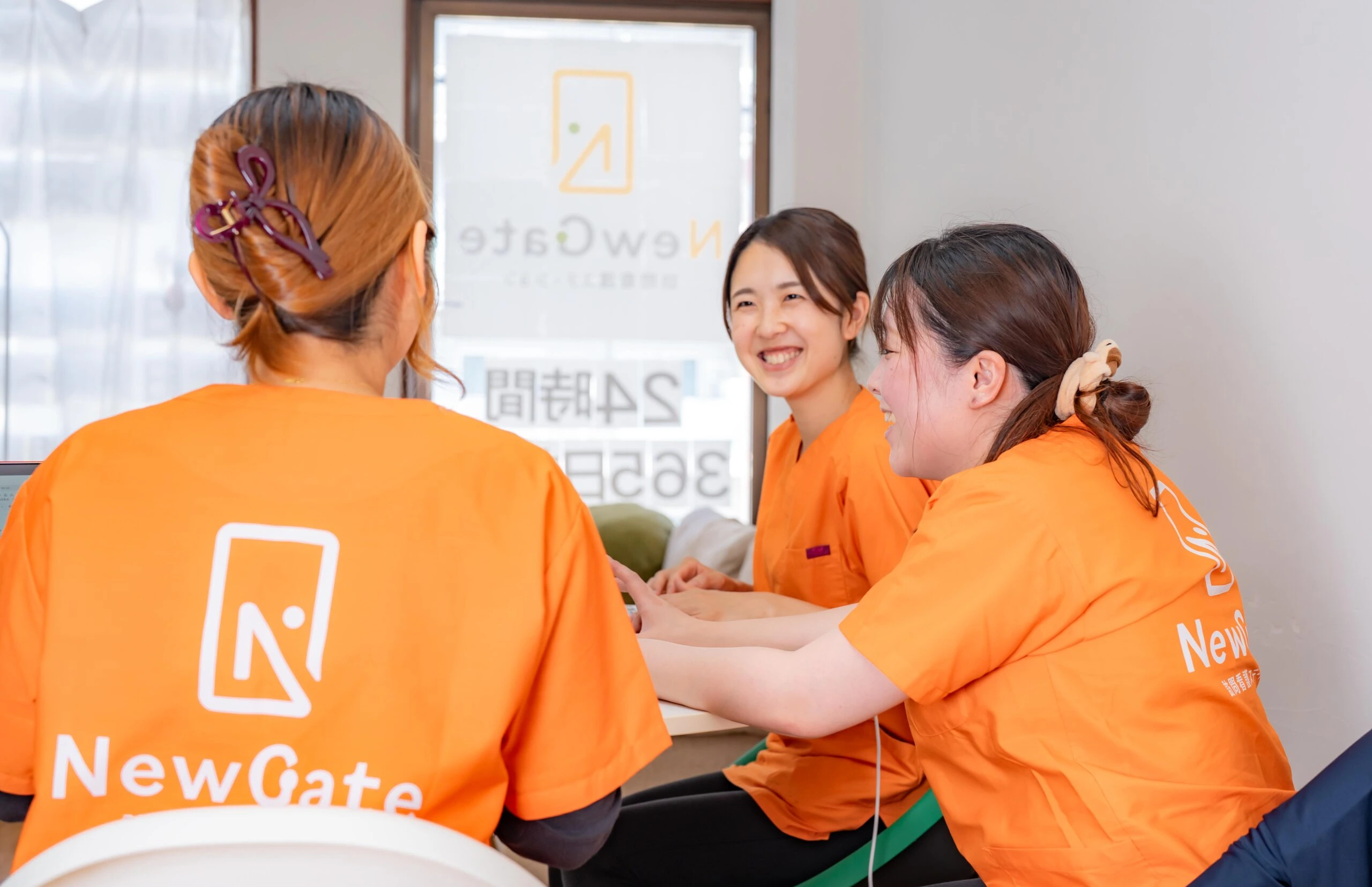 パソコンを囲んで打ち合わせをするスタッフ